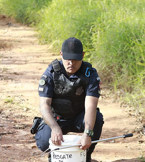 Celso Junior fechando a tampa do balde com o animal resgatado